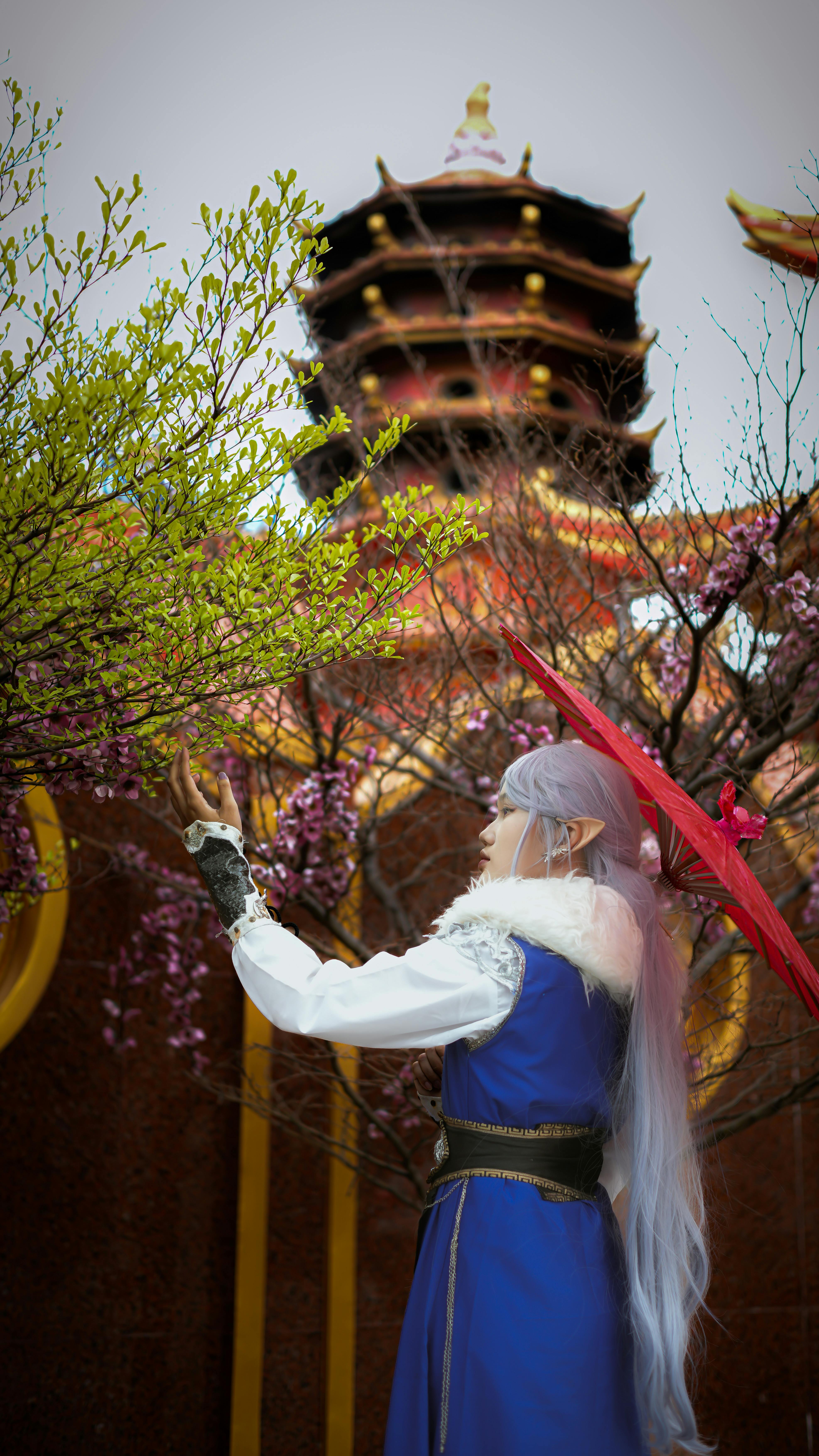 A stunning cosplay performance set against a traditional Asian garden, showcasing vibrant colors and architecture.