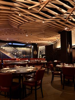 Elegant restaurant interior featuring wooden ceiling and red leather seating.