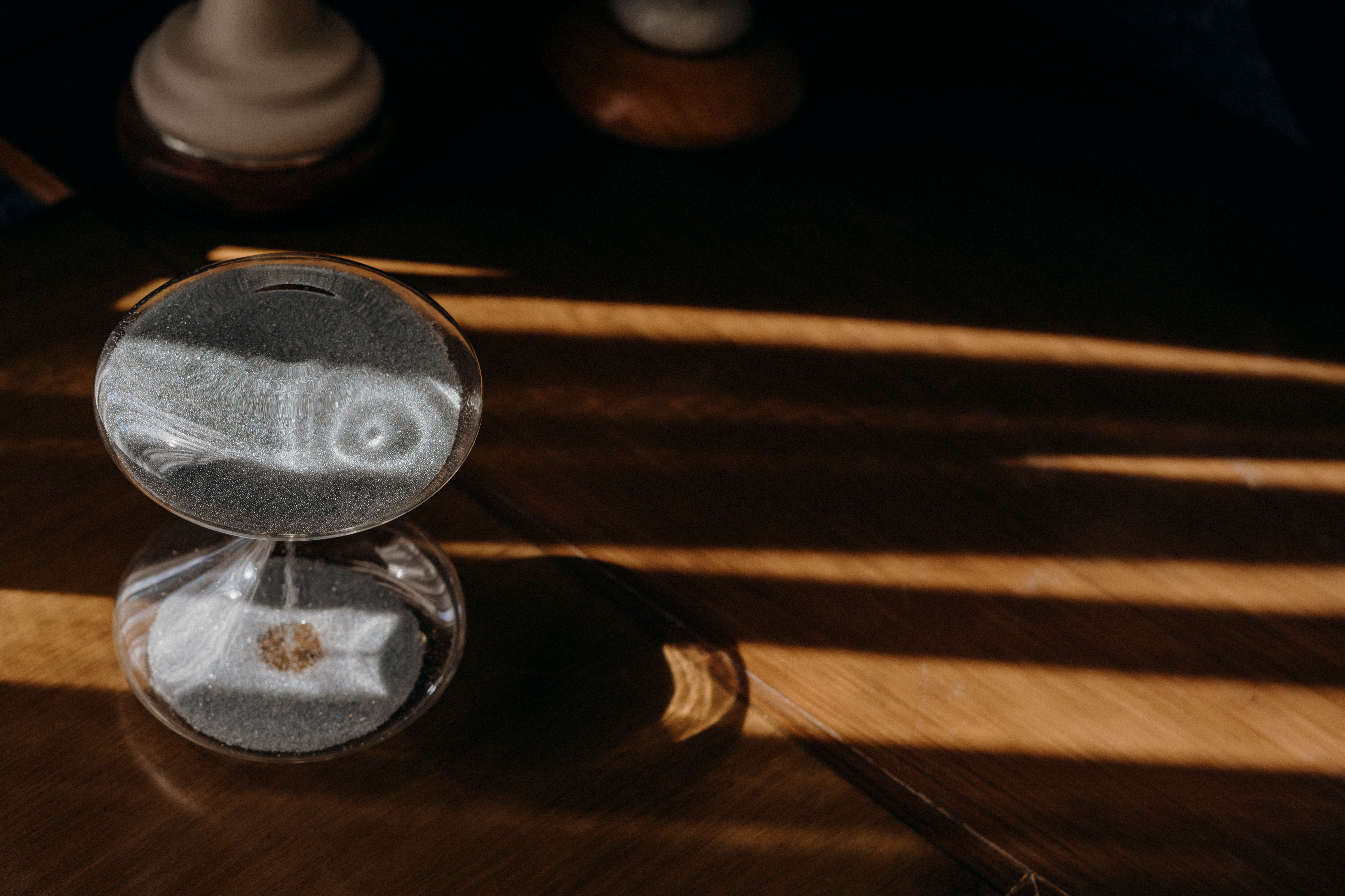 Sand Timer in Morning Sunlight on Wooden Table · Free Stock Photo