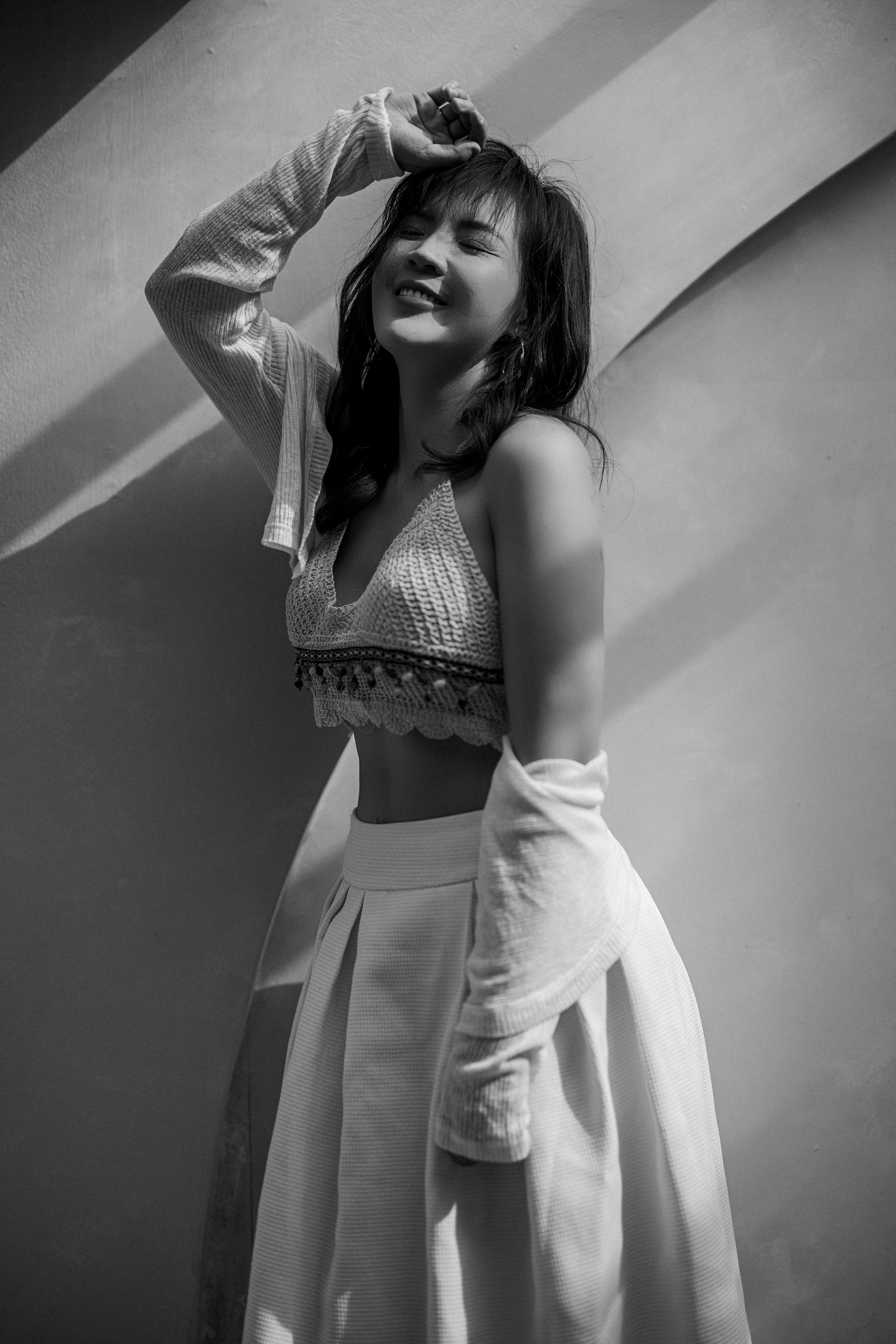 Elegant black and white portrait of a joyful woman in stylish attire, showcasing modern fashion.