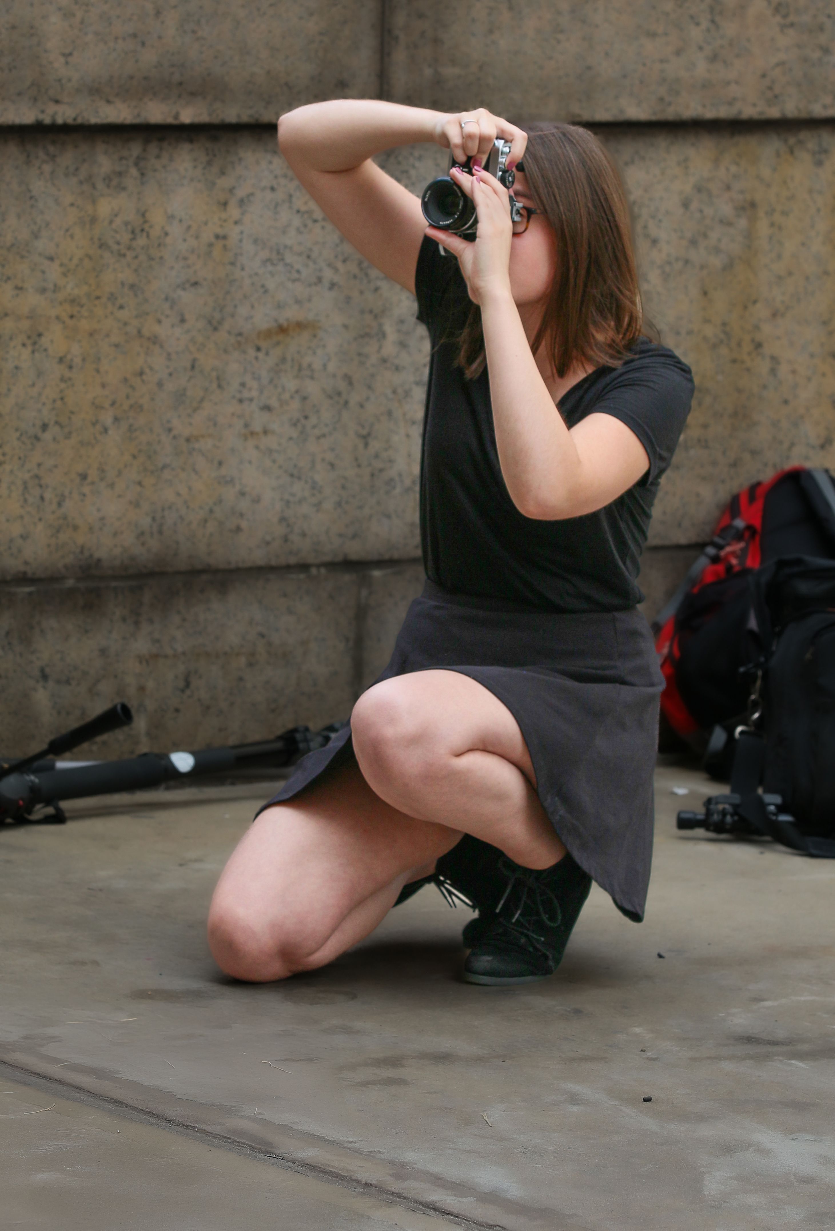 A dedicated photographer kneeling to capture a street moment in New York City.