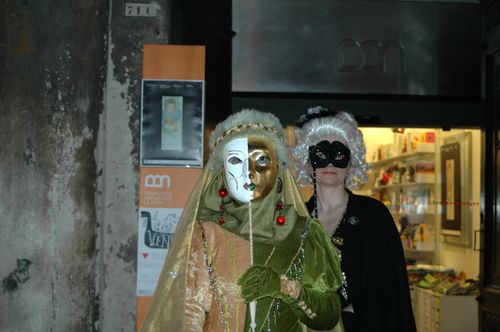 Free Two costumed figures with masks during Venice Carnival nighttime. Stock Photo