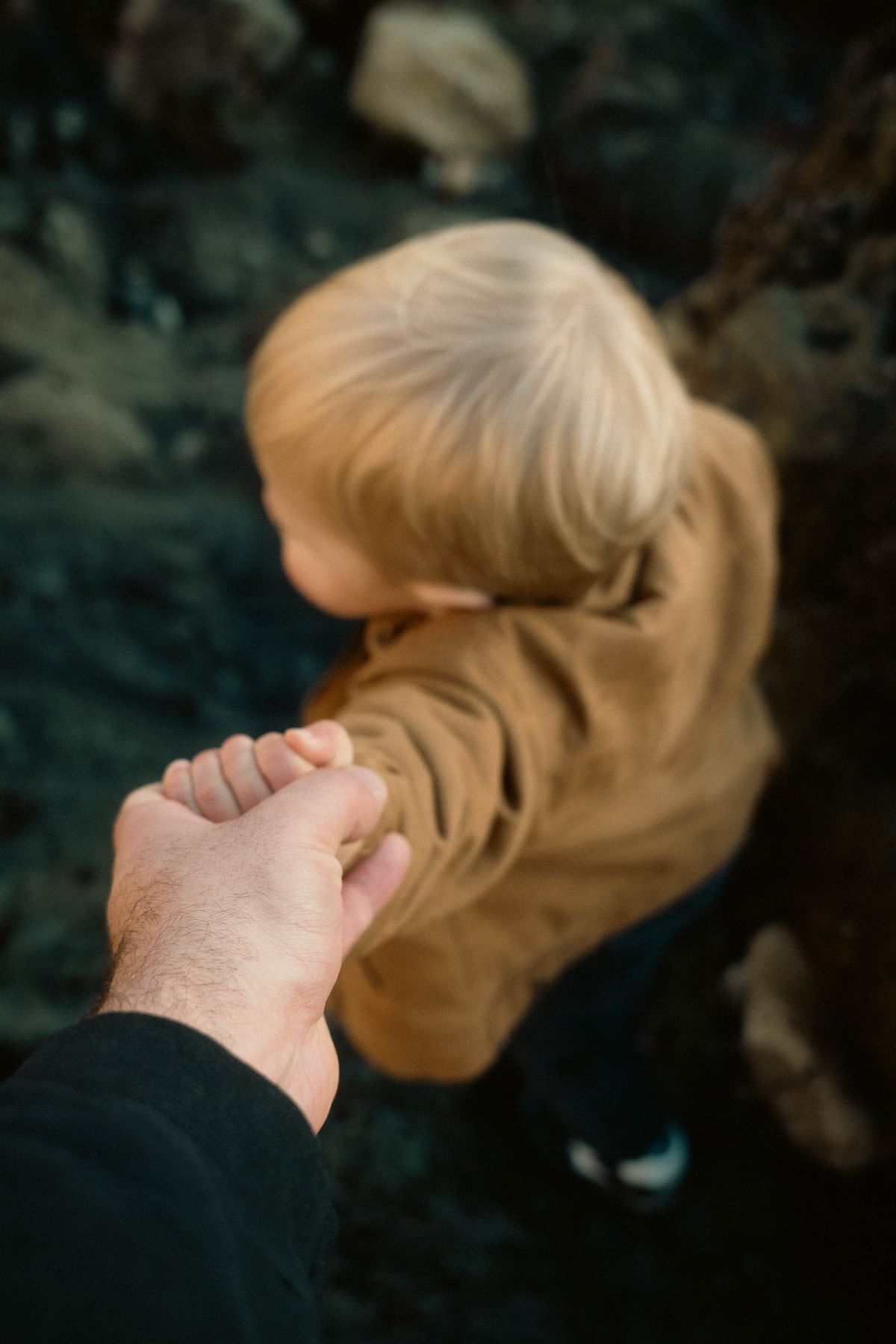 Parent holding a child's hand during a calm outdoor moment