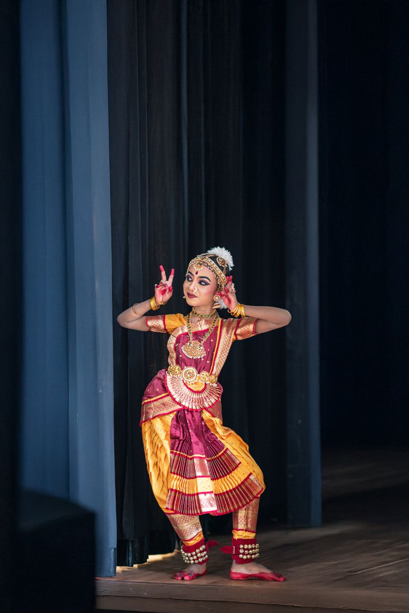 Young dancer in traditional attire performing a classical Indian dance pose