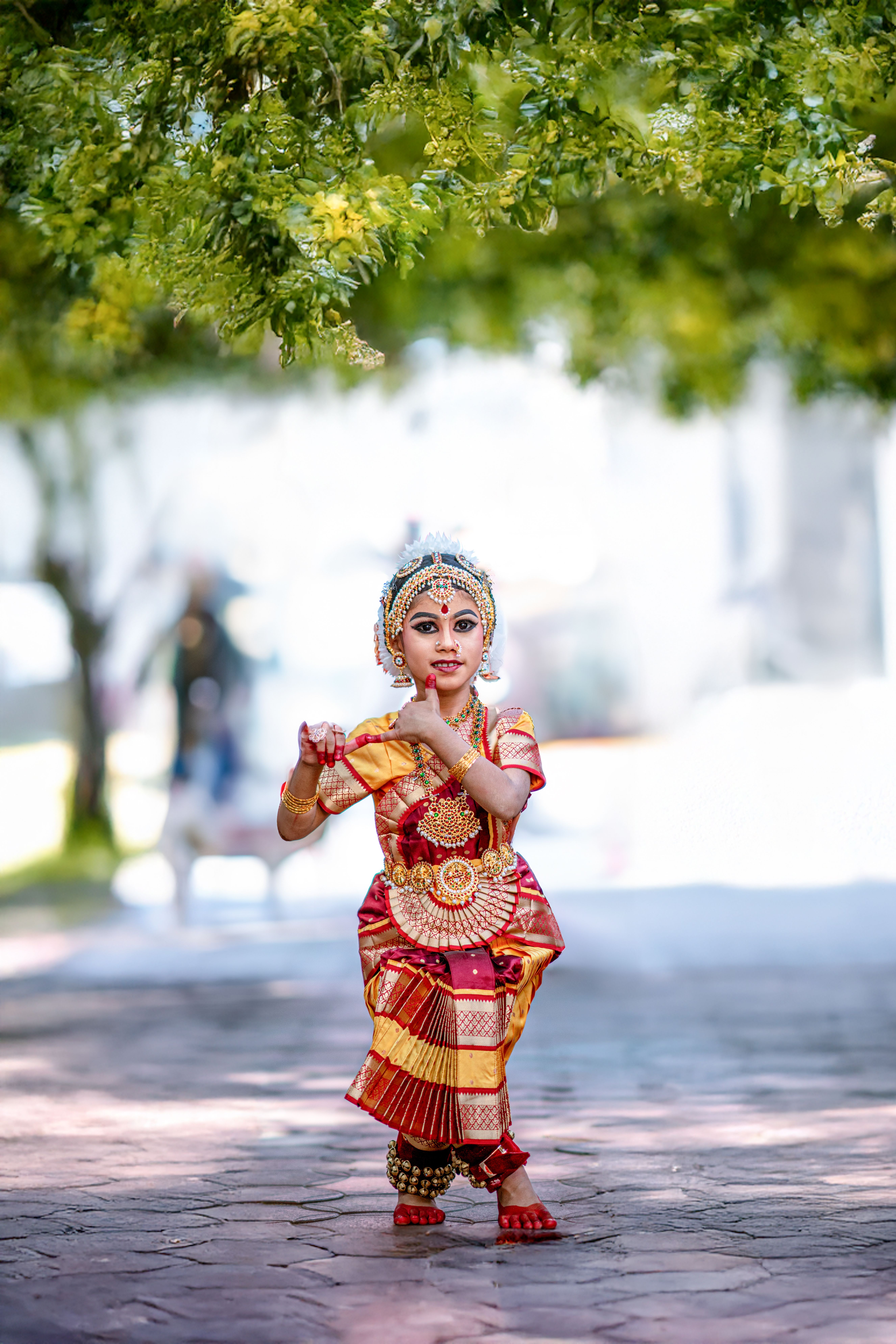 Young girl in traditional costume performing classical dance outdoors in Kerala.
