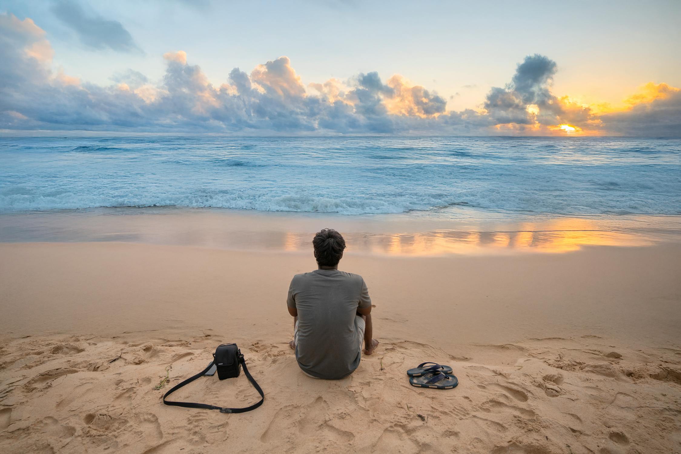 Serene Beach Sunset with Man Reflecting · Free Stock Photo