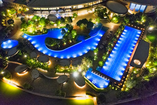 Aerial Photo of Illuminated Outdoor Swimming Pools In Various Shapes At Night