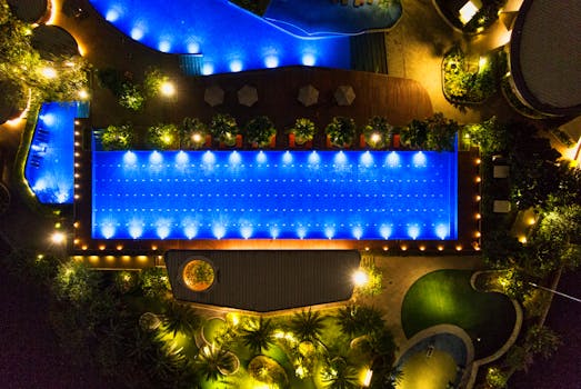 无人机拍摄了印度尼西亚万丹度假村的霓虹灯泳池，夜间景象优雅，令人惊叹