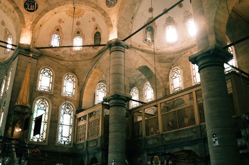 Free Beautifully lit dome interior of a historical mosque with intricate stained glass windows. Stock Photo