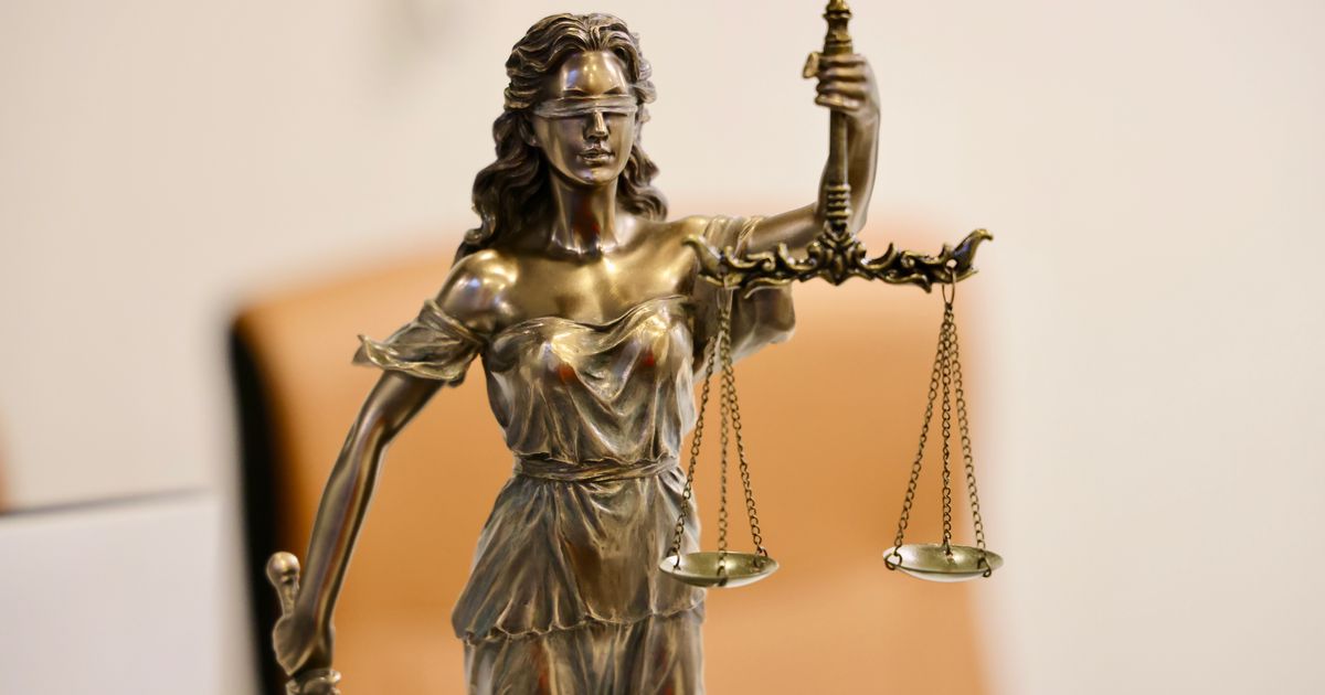 A bronze Lady Justice statue holding balanced scales and a sword, symbolising the Australian legal system