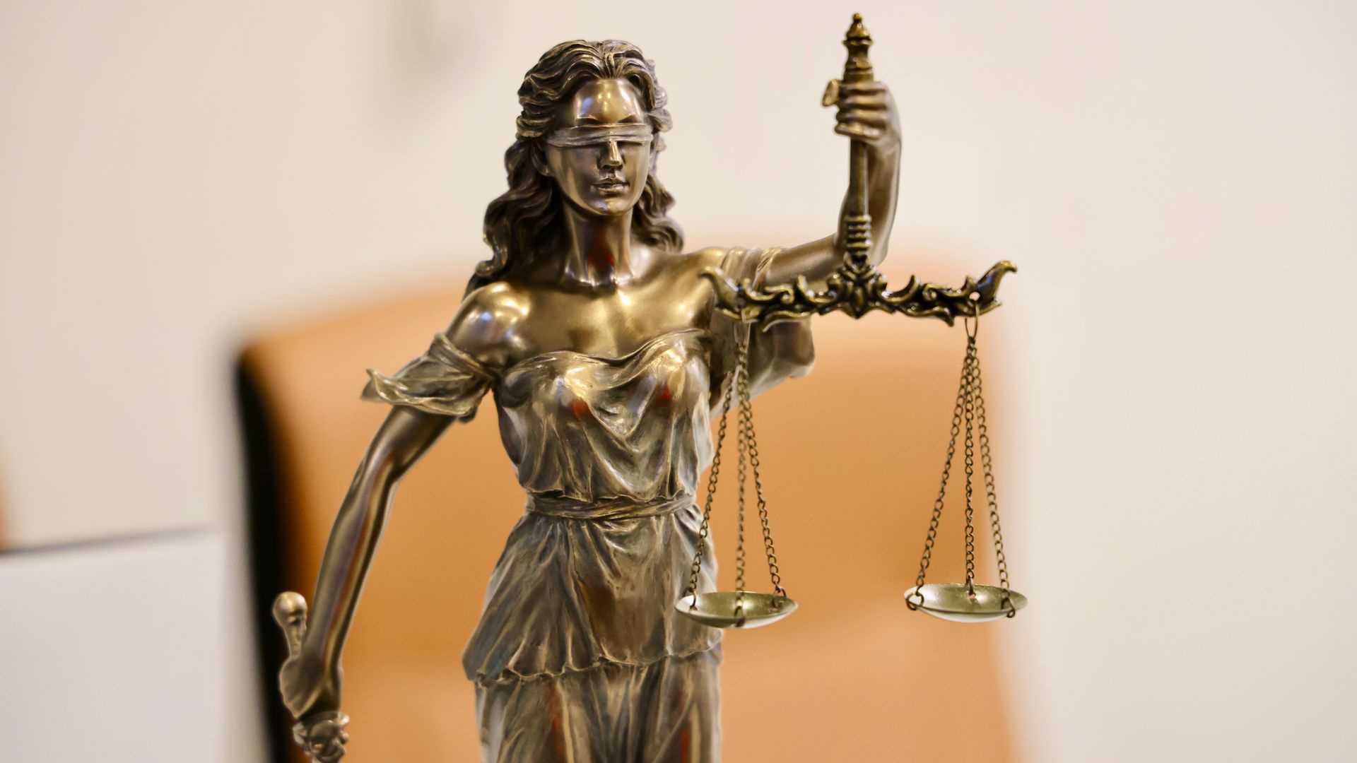 Close-up of Lady Justice statue holding scales, symbolizing justice and fairness — what does sustained mean in court
