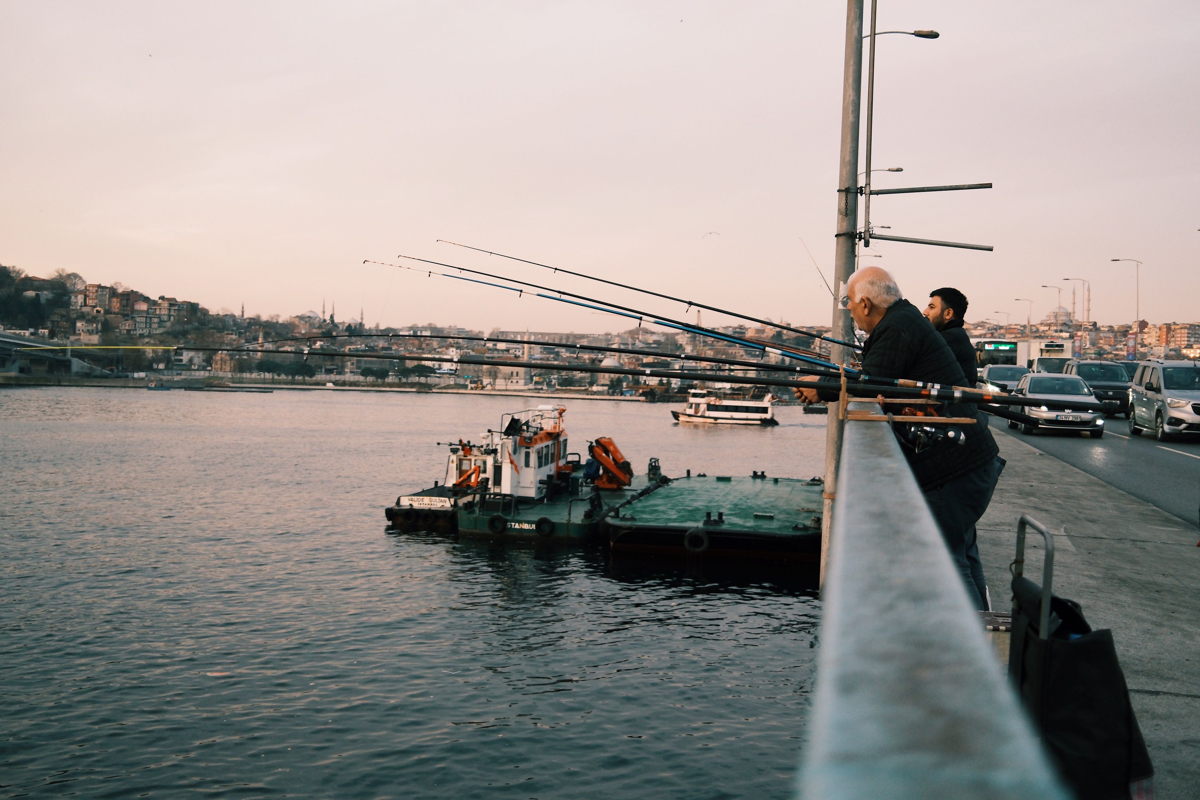 Fishermen Cast Lines from a City Bridge at Dusk · Free Stock Photo