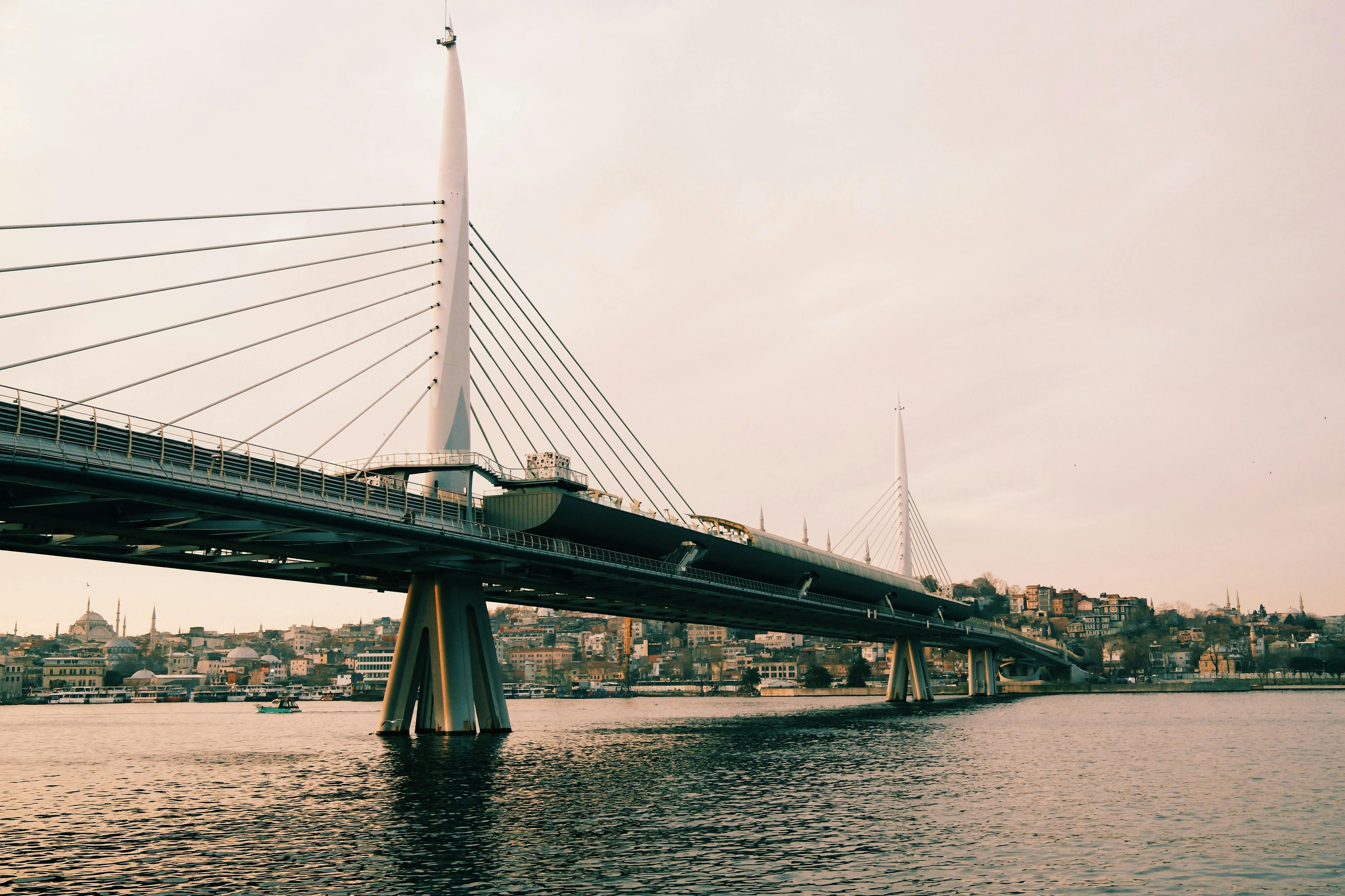 Gratuit Une vue du pont du métro de la Corne d'Or traversant l'eau à Istanbul au coucher du soleil. Photos