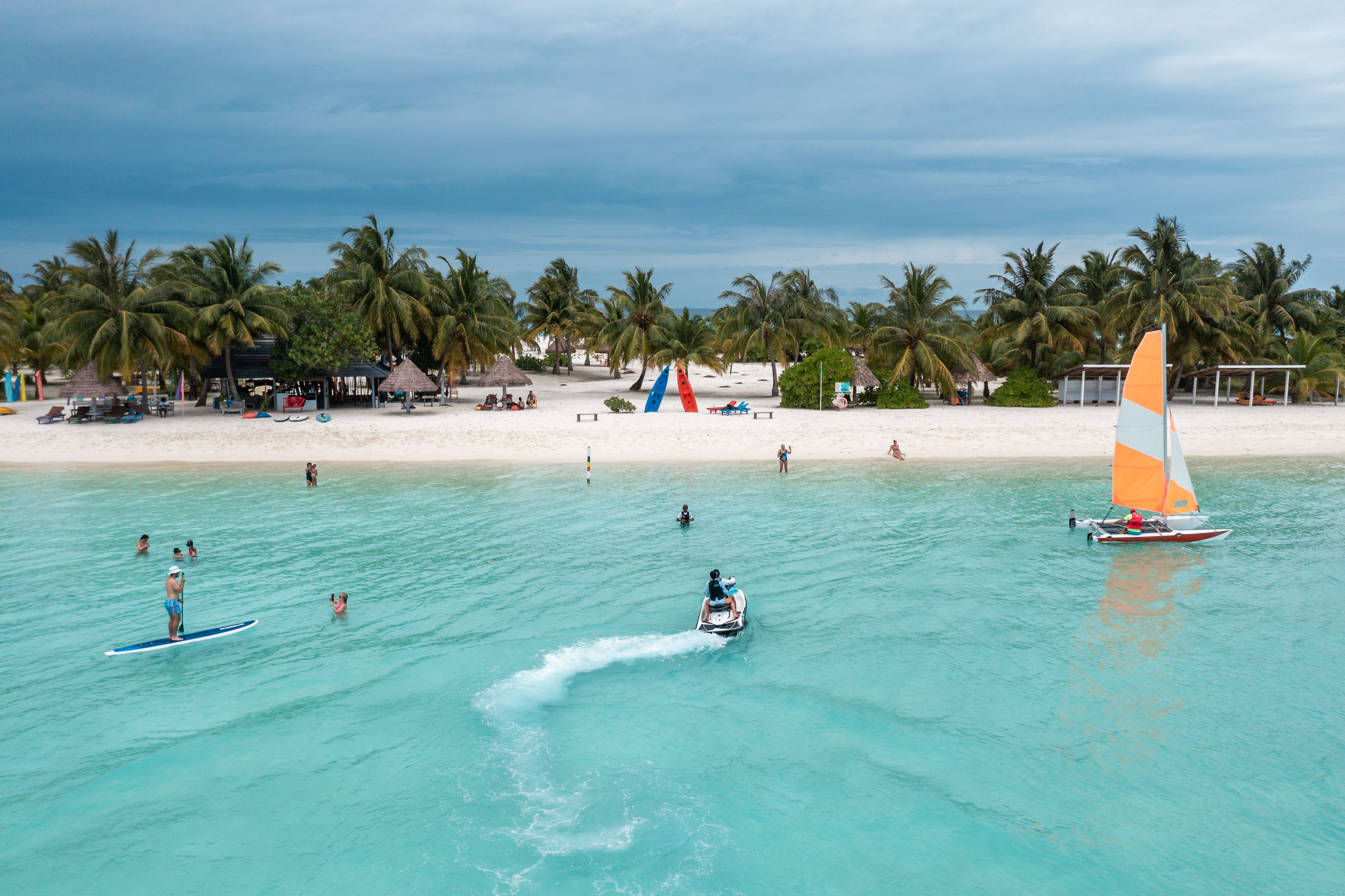 Enjoy a vibrant day with water sports and sailing at a pristine Maldivian beach.
