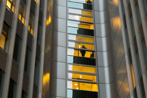Free Reflection of a person in a modern Berlin building's glass facade with sleek architecture. Stock Photo