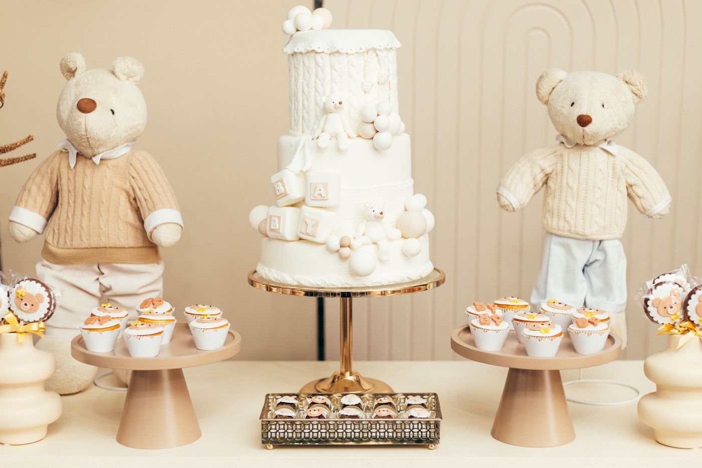 Soft neutral baby celebration with cake and teddy bears