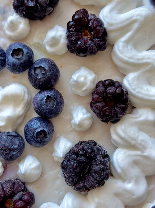 Free Delicious close-up of blueberries and blackberries with dollops of whipped cream. Stock Photo