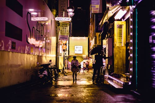 People Walking Near Road Beside Buildings during Night Time
