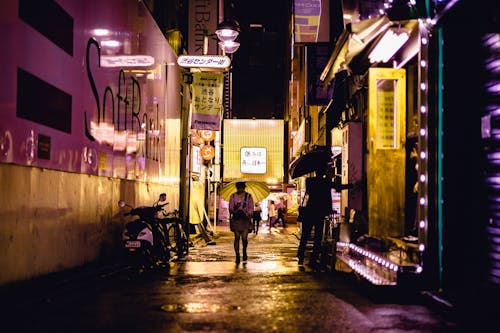 Persone Che Camminano Vicino Alla Strada Accanto Agli Edifici Durante La Notte