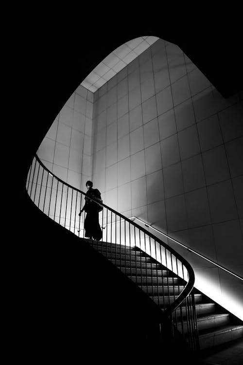 グレースケール写真で階段を歩いている人