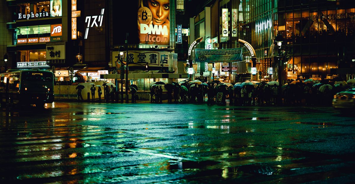 Tokyo street at night in the rain with neon signs reflecting on wet pavement