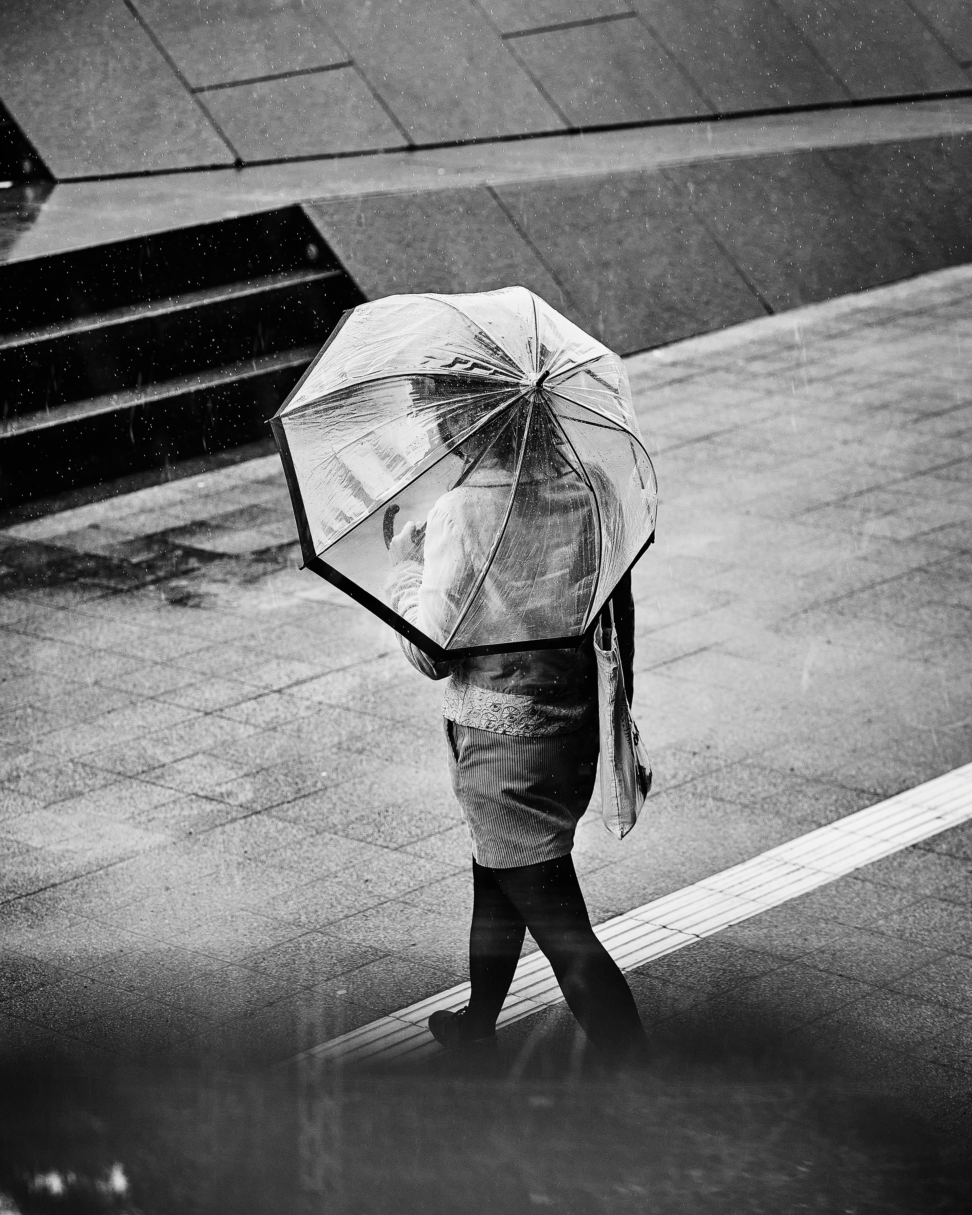 免費 漢堡下雨天，一個人撐著傘行走的黑白照片，營造齣戲劇性的城市場景。 圖庫相片