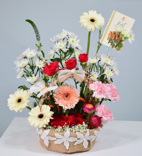 Free Beautiful floral bouquet in a decorative basket, featuring roses and daisies, photographed indoors in Dubai. Stock Photo