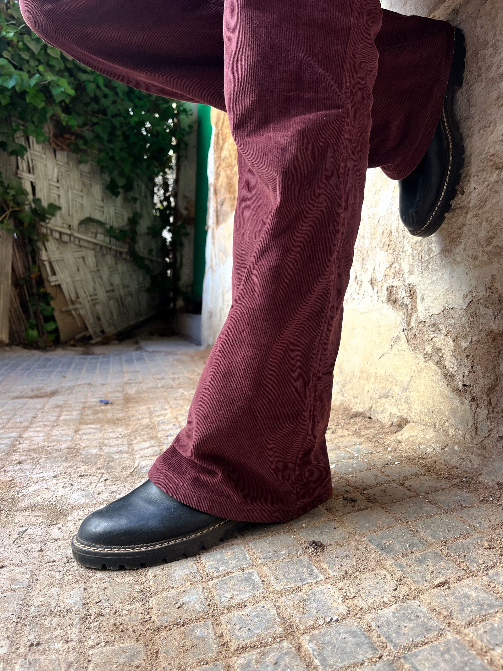 Maroon corduroy pants styled with rugged black boots