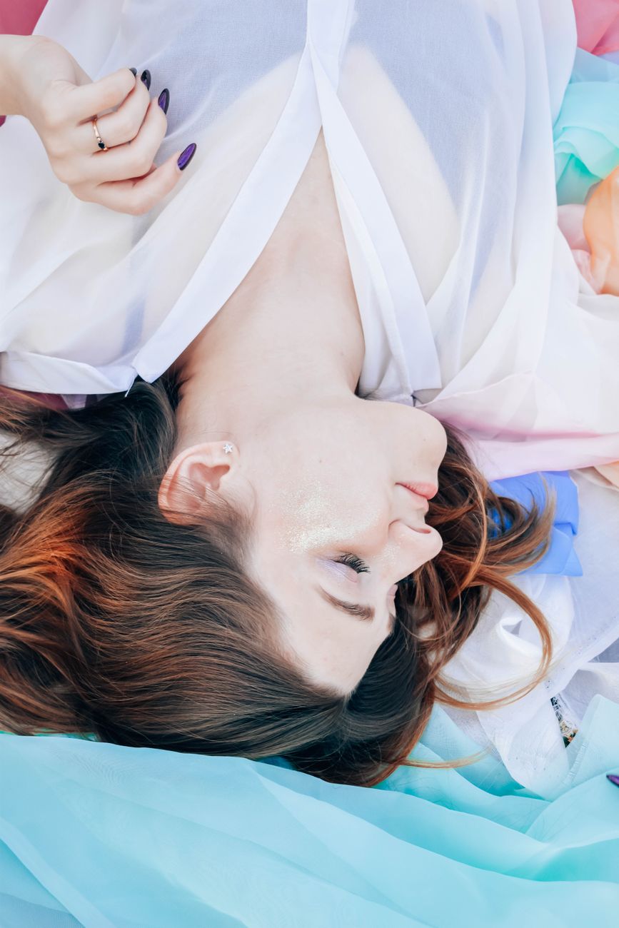 Elegant portrait of a young woman with flowing fabric embodying tranquility and grace.