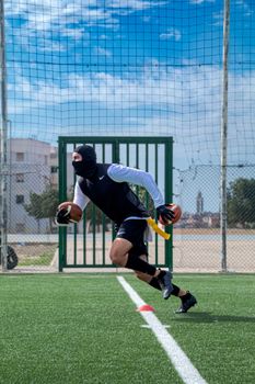 Athlete playing American football on a grassy field in Rabat, Morocco.