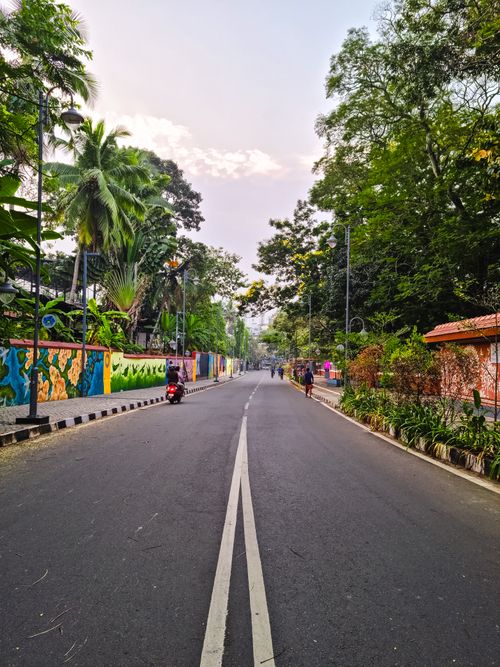 Free Vibrant street scene in Thiruvananthapuram, Kerala, featuring colorful murals and lush greenery. Stock Photo