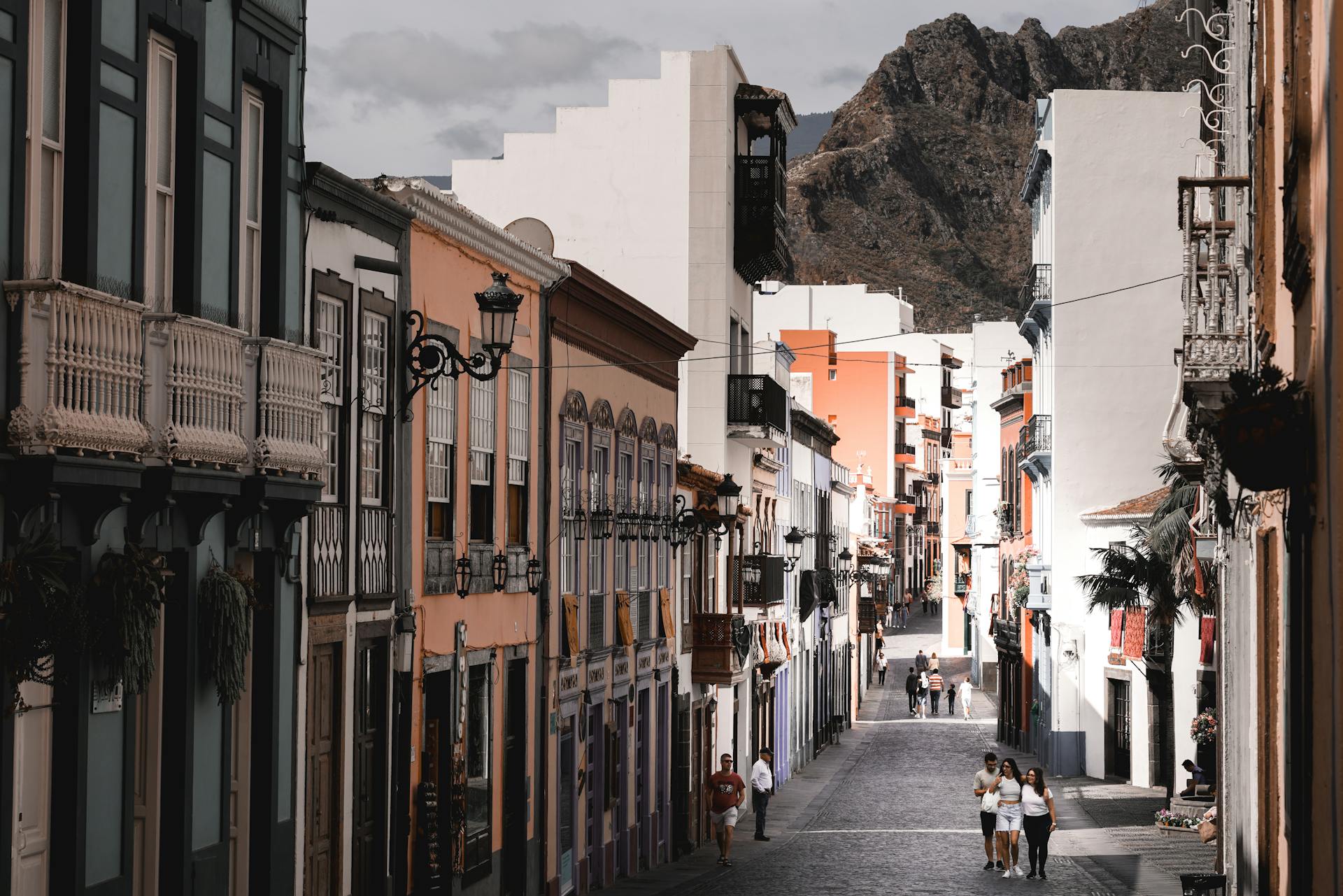 Scenic street view with colorful European architecture and mountain backdrop.