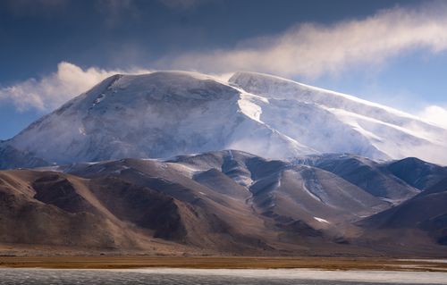 Free Breathtaking view of a snow-covered mountain range at sunrise, with clear skies and dramatic landscape. Stock Photo