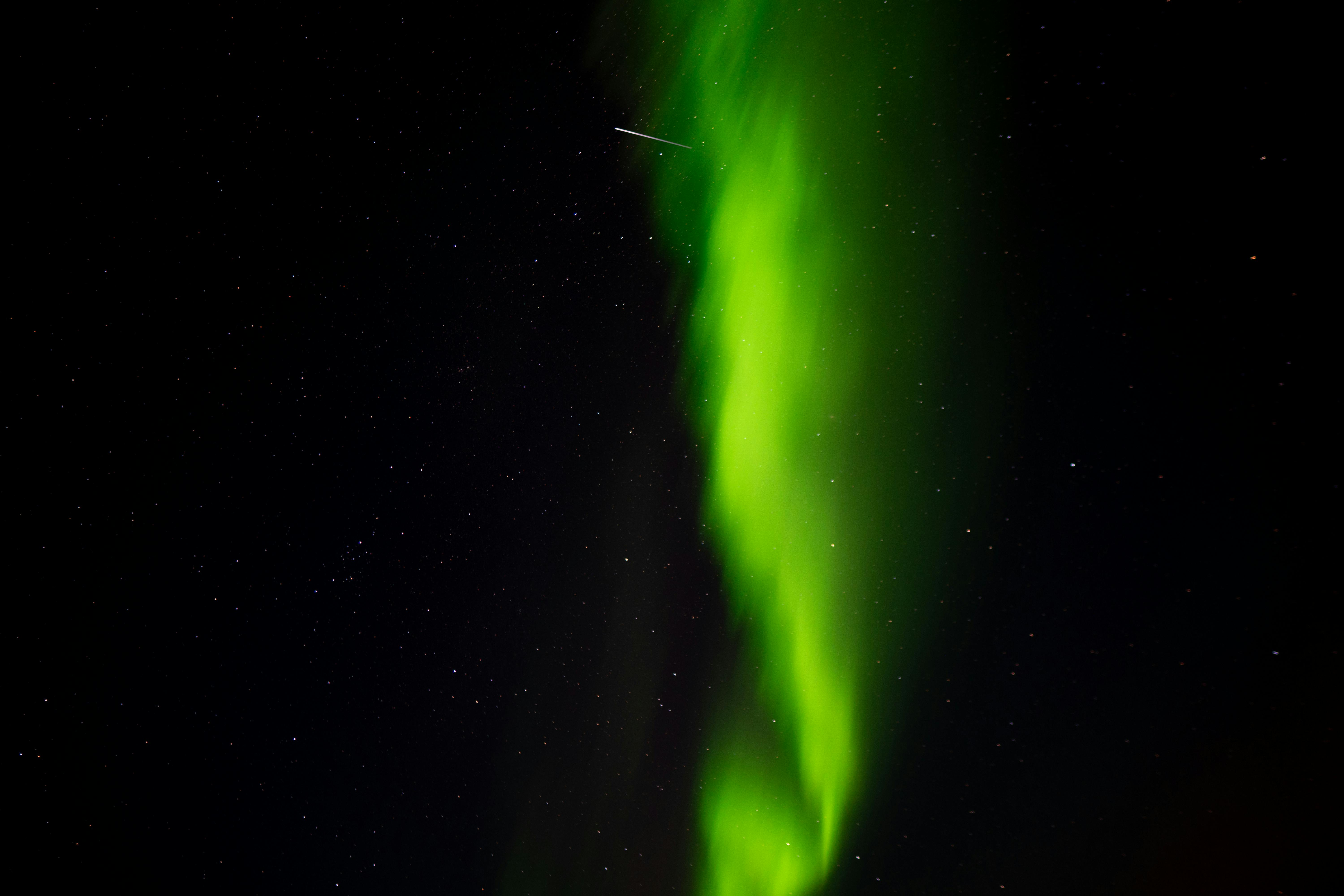 Captivating display of aurora borealis with bright stars at night in Islandija.
