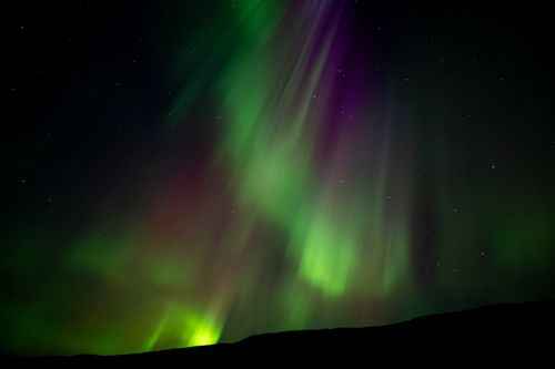 Free Captivating view of aurora borealis illuminating Islandija's night sky with vibrant colors. Stock Photo