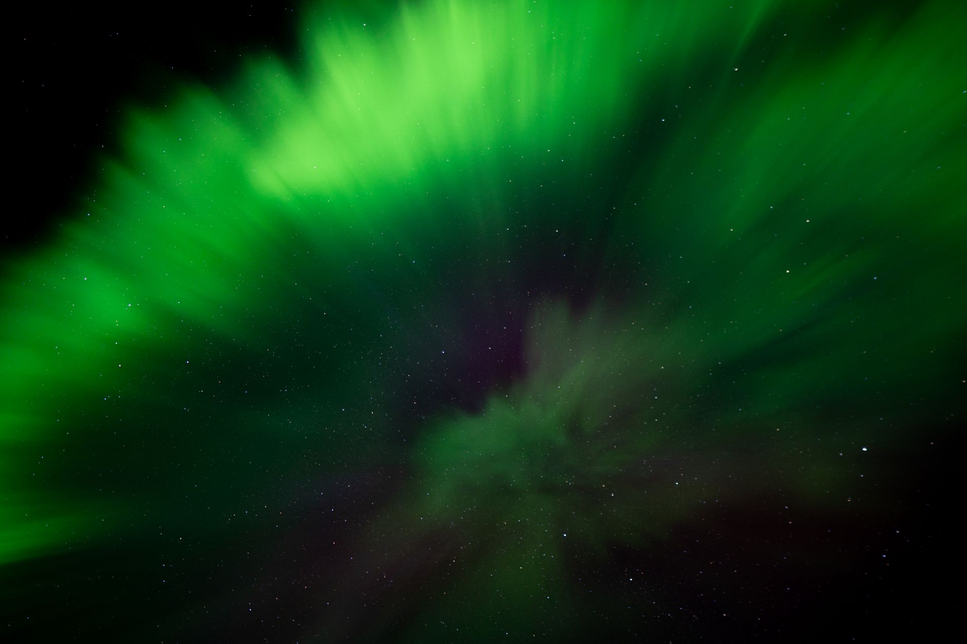 Green aurora dancing over a snowy Icelandic landscape