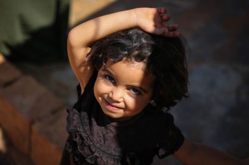 Free Adorable child smiling under sunlight in Idlib, Syria. Stock Photo