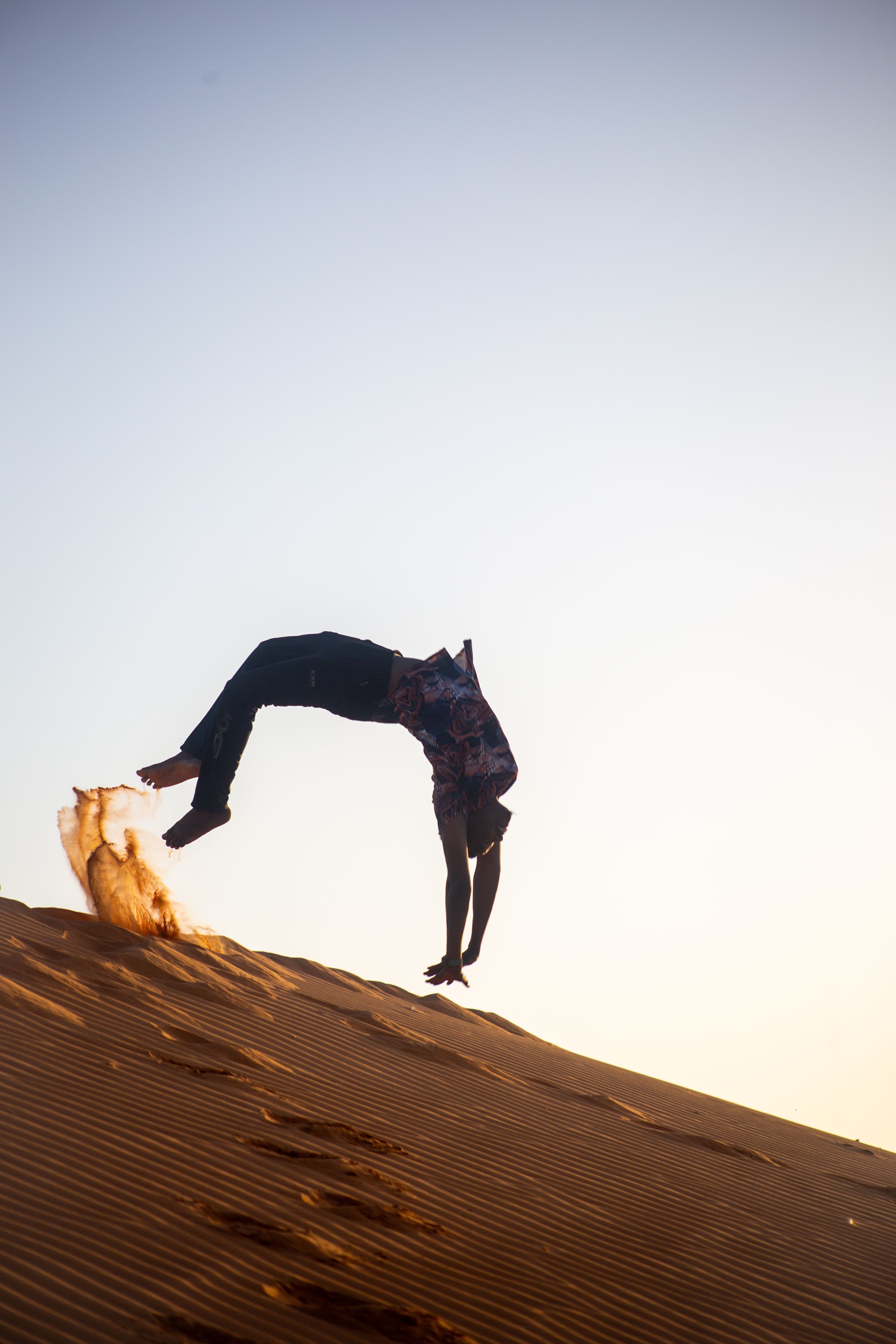 Dynamic Backflip on Sunlit Sand Dunes · Free Stock Photo