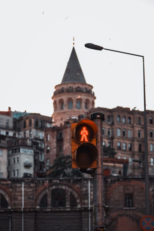 Free Red pedestrian traffic light with Galata Tower in the background at dusk. Stock Photo