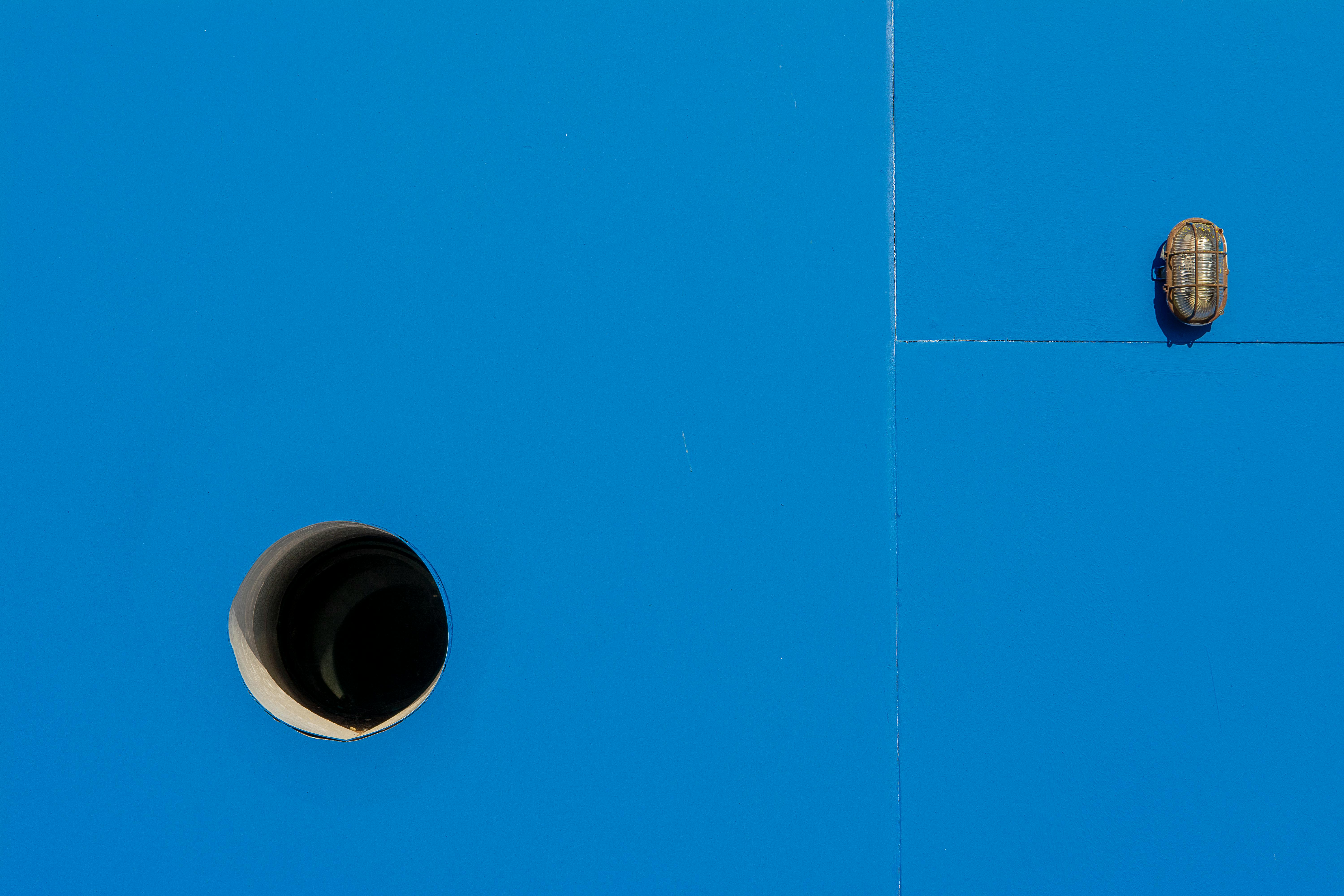 gratis Een minimalistische compositie met een kever op een felblauw oppervlak met een ronde pijp. Stockfoto
