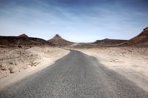 Free Serene Desolate Road through the Moroccan Desert in M'Hamid El Ghizlane. Stock Photo
