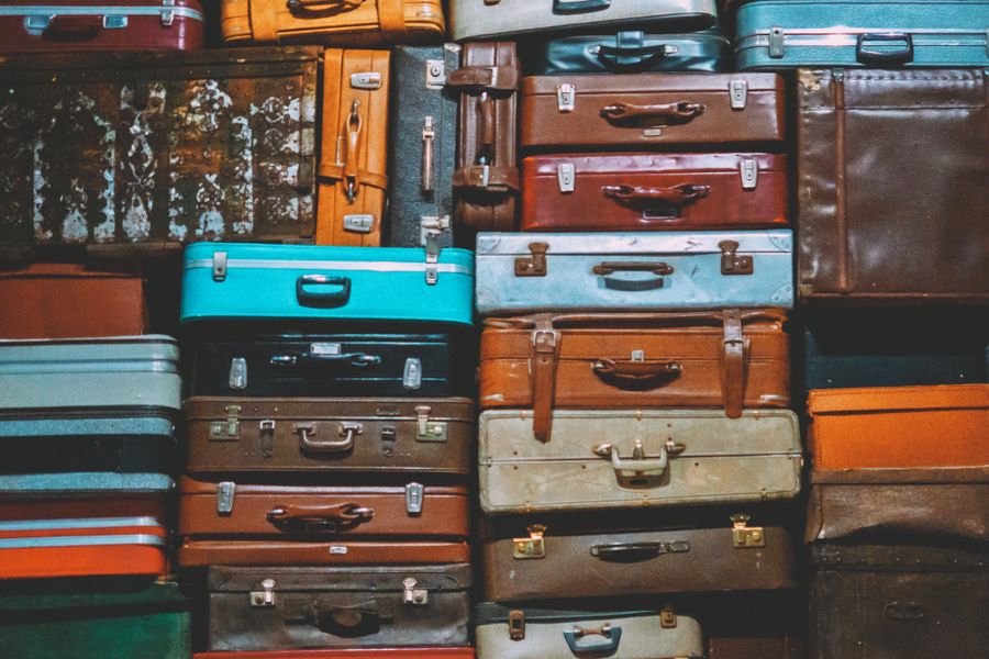 A colorful assortment of vintage suitcases stacked together, creating an artistic display.