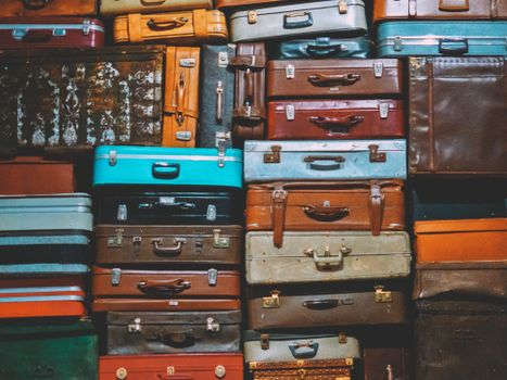A colorful assortment of vintage suitcases stacked together, creating an artistic display.
