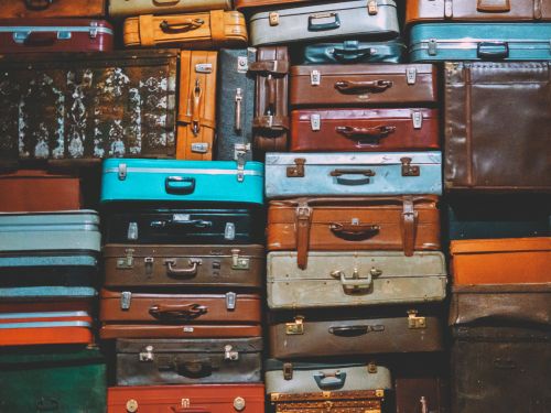 Free A colorful assortment of vintage suitcases stacked together, creating an artistic display. Stock Photo