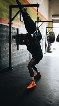 Boxer working out in a gym with punching bag, showcasing intense focus and athleticism.