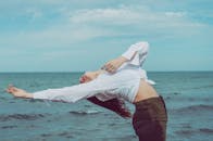 一名女子在海边表演瑜伽姿势，捕捉到平衡和宁静的时刻