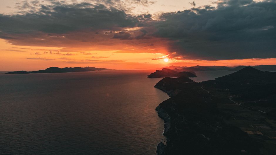 Captivating aerial view of a sunset over the Croatian coast, showcasing vibrant colors and serene waters.