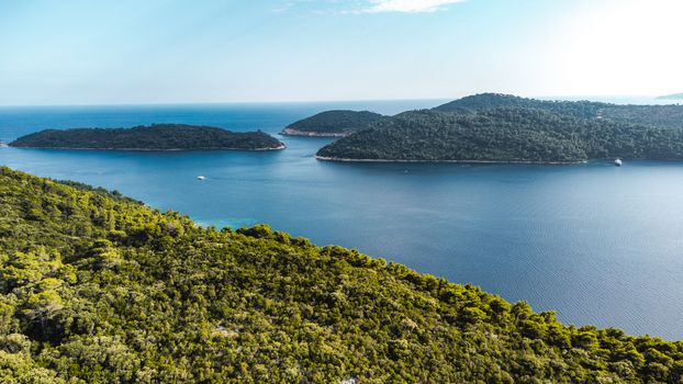 Beautiful aerial view of lush islands surrounded by blue sea in Dubrovnik-Neretva County, Croatia.