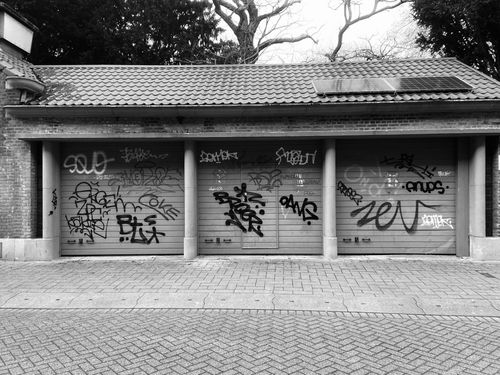 Free Three garage doors with graffiti art showcasing urban street style in black and white. Stock Photo