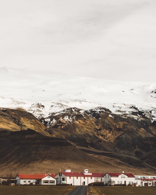 Una Pequeña Ciudad Al Pie De Las Montañas Cubiertas De Nieve